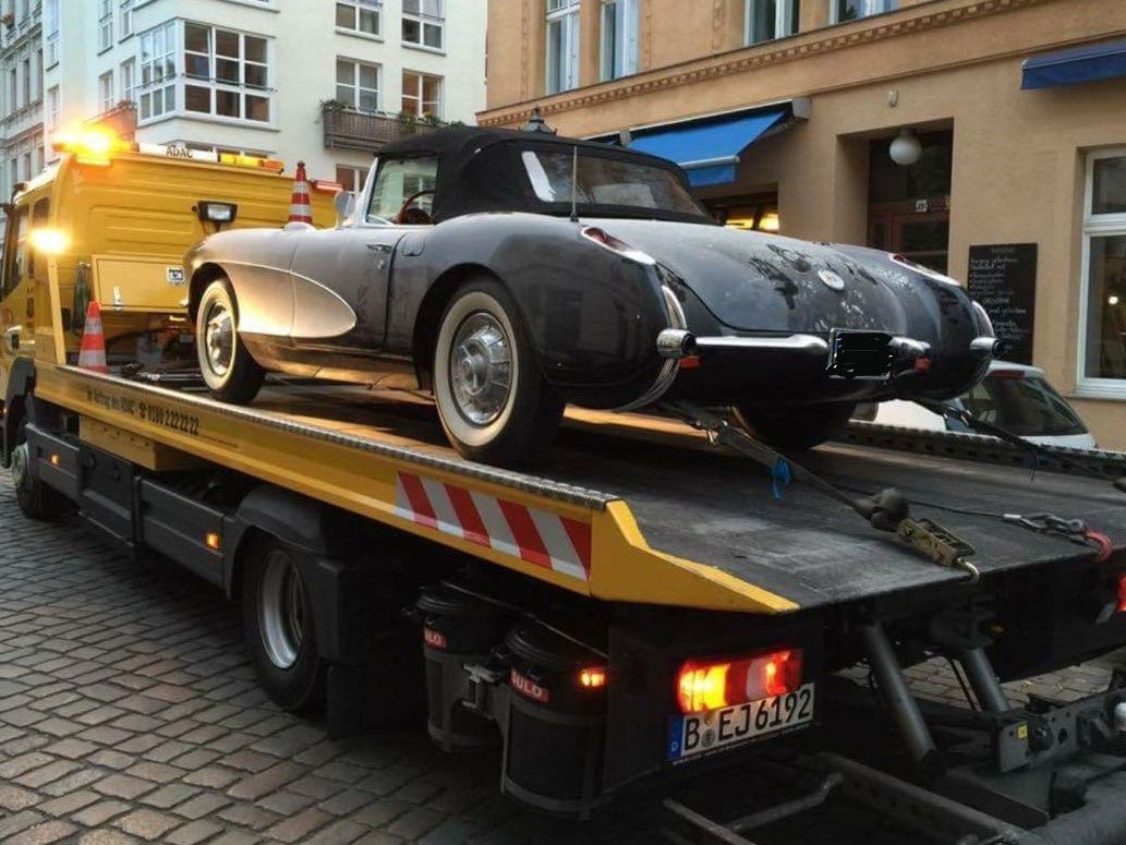 Oldtimer auf ADAC-Abschleppwagen in einer Innenstadtstraße.